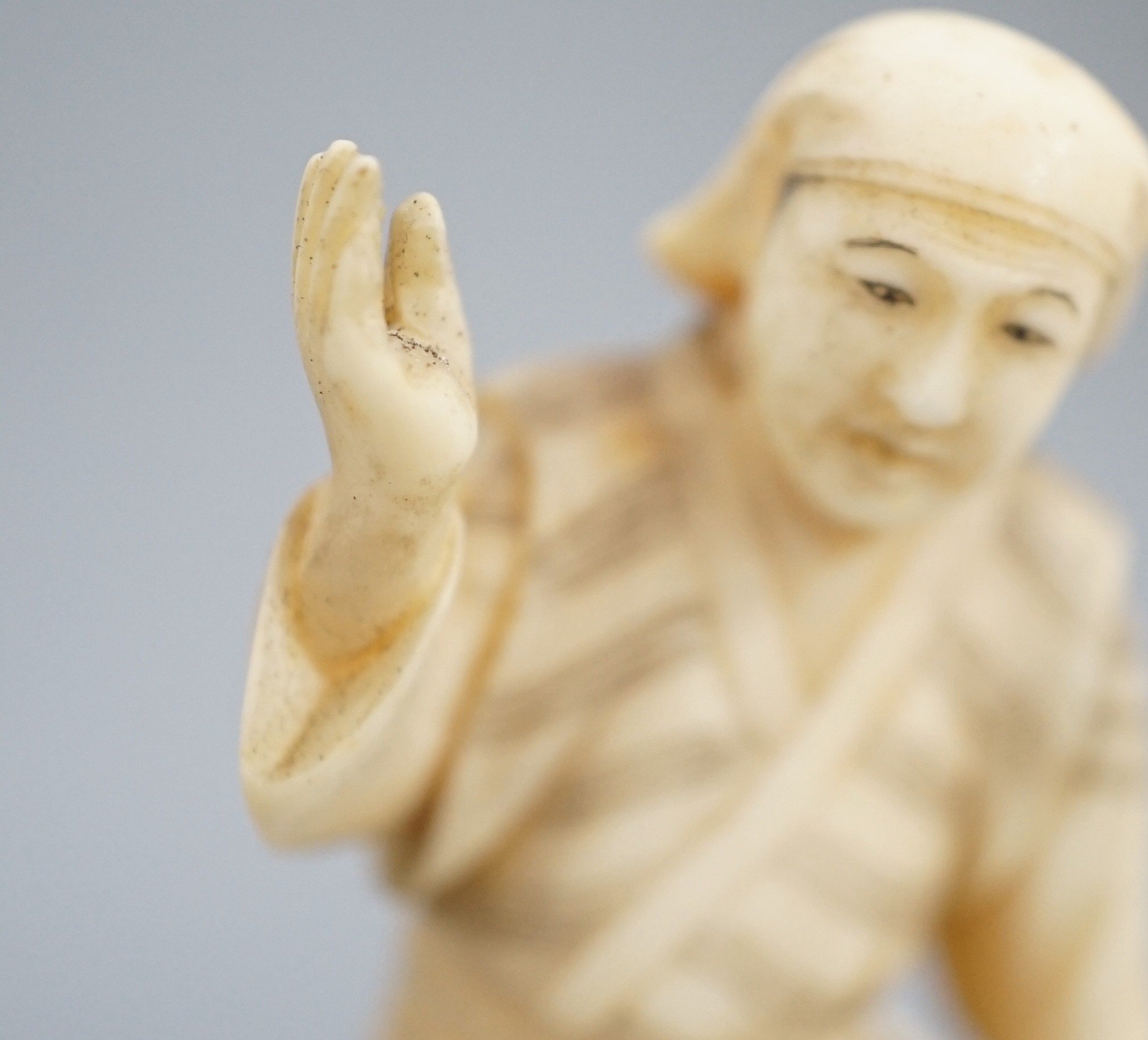 A Japanese ivory okimono of a monkey trainer, signed, Meiji period, 7.7 cm